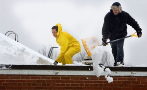 Eric Figueroa and Jonathan Morreno of Green Construction work to shovel a 5-foot snowdrift from the top of Community School in Prospect Monday. Schools in Naugatuck and Region 16, which serves Prospect and Beacon Falls, have been closed since Friday when a blizzard dumped about 3 feet of snow in the area. –RA ARCHIVE 
