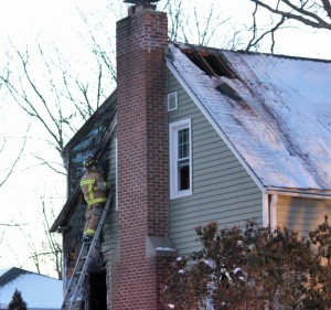 A Naugatuck firefighter works at he scene of a house fire at 100 Conrad St. in Naugatuck Wednesday afternoon. –ELIO GUGLIOTTI 