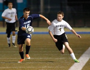 Woodland's Jack LaPerriere (4) and Oxford's Jason Cadilek chase after the ball during the NVL semifinal Tuesday in Waterbury. Woodland won, 1-0.  -REPUBLICAN-AMERICAN